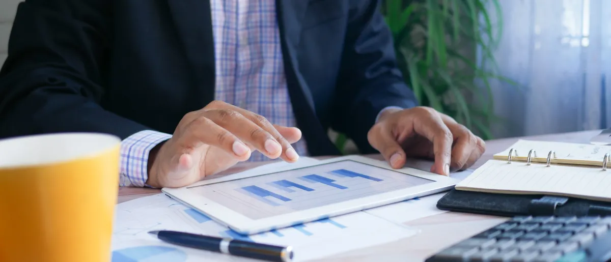 A person working on a budget with a calculator and coffee near