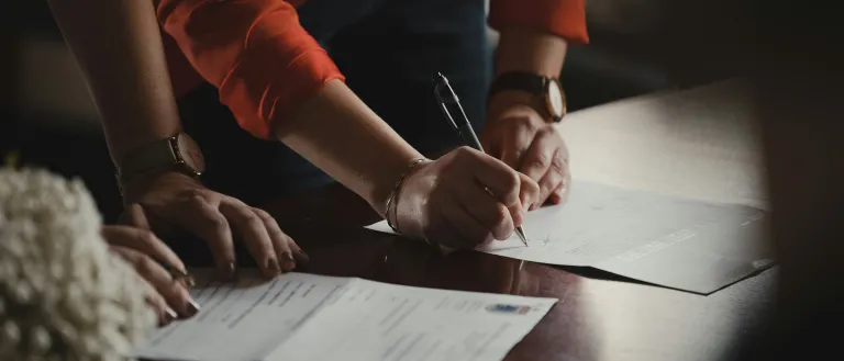 2 people working side by side on paperwork