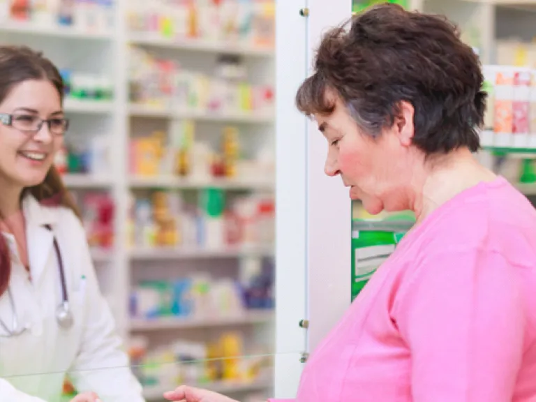 A woman stands at the pharmacy counter