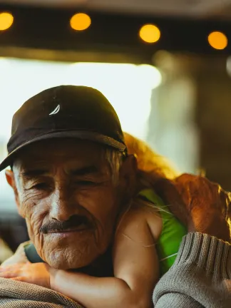 A senior man hugging his small grandchild 