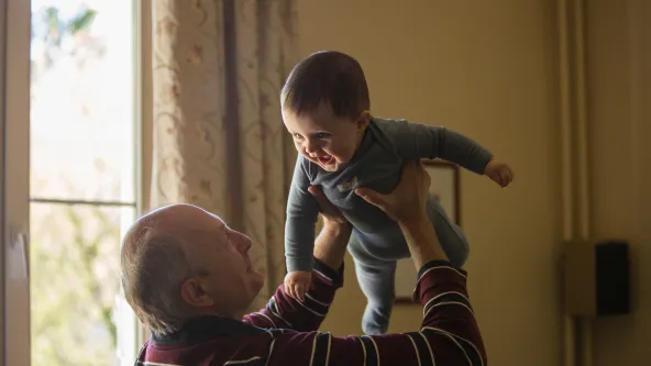 Grandpa holding baby up in air