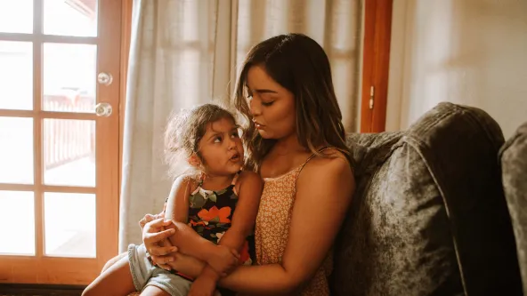 A mom with her young daughter on her lap